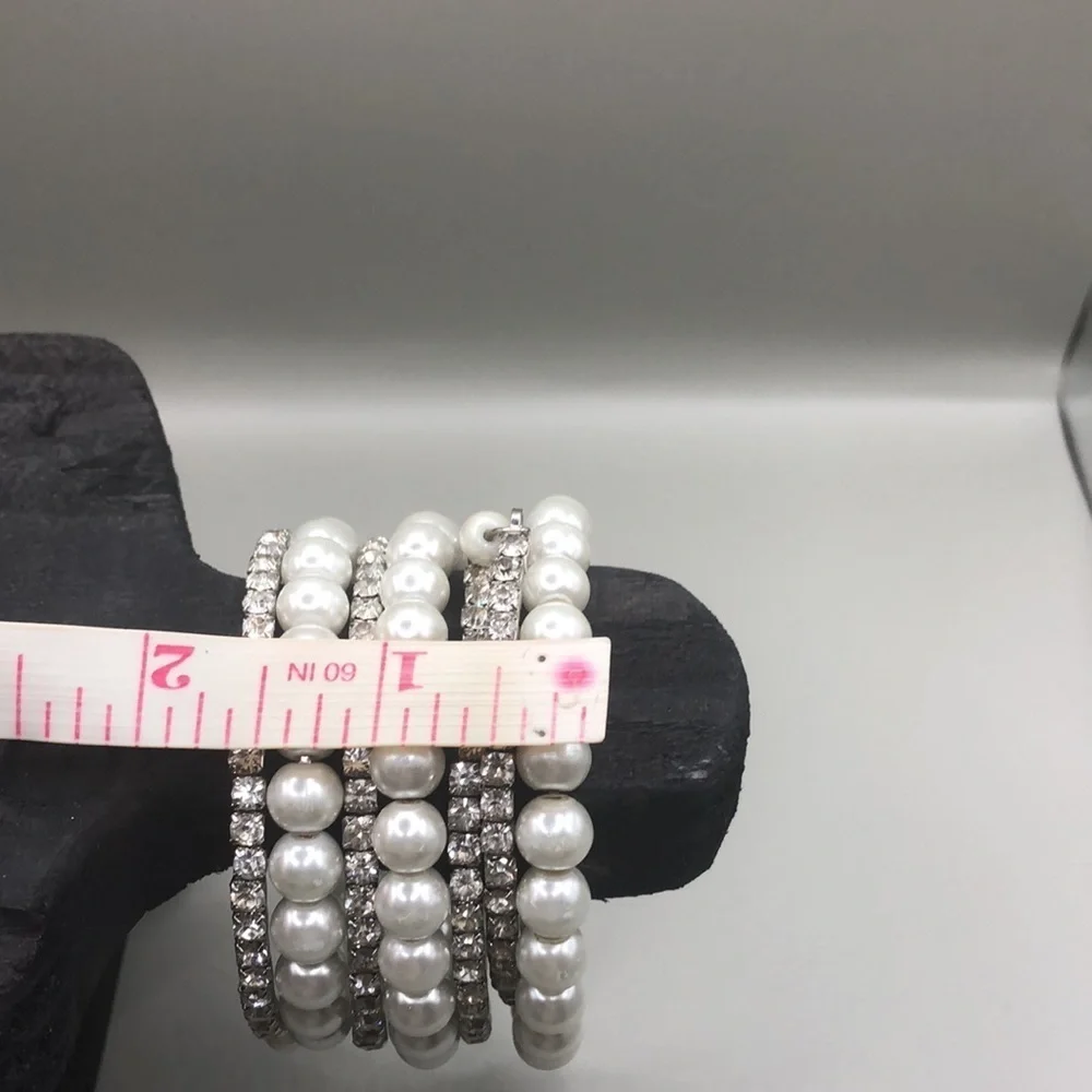 Faux pearls and rhinestones coil statement bracelet wide.